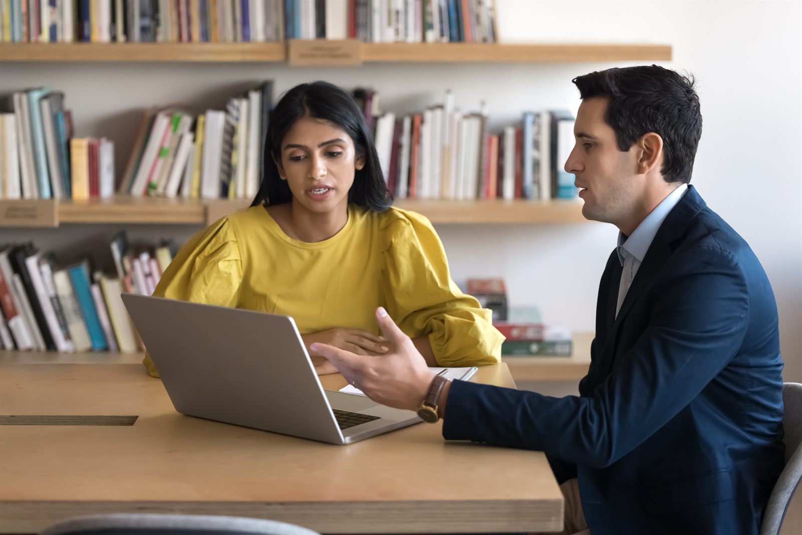 A CPA reviewing financial reports on a laptop with a small business owner