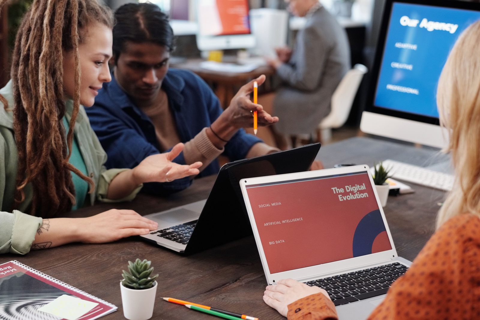 An agency team reviewing campaign slides on laptops in a studio