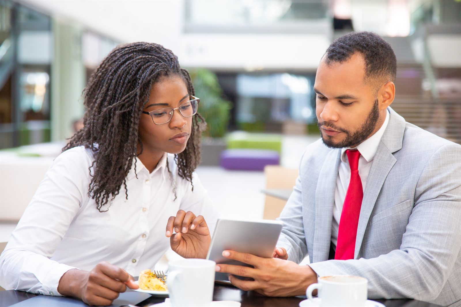 A CPA reviewing year-end tax projections on a tablet with a business owner